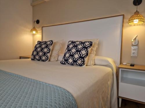 a bedroom with a large bed with pillows on it at Hotel Bodegón de Peñíscola in Peñíscola