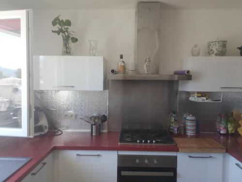 une cuisine avec des armoires blanches et un four à plaques de cuisson dans l'établissement Villa Sainte-Lucie, à Calvi