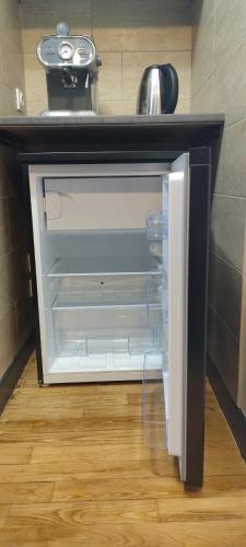 un réfrigérateur vide avec une porte ouverte dans une pièce dans l'établissement Chez Philippe et Agnès Studio, à Vauciennes