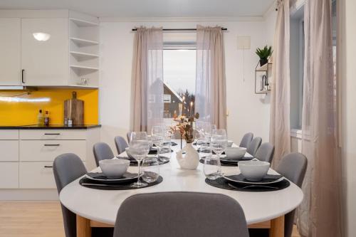a white dining room with a white table and chairs at Near Downtown - Large Beds - Free Parking in Tromsø