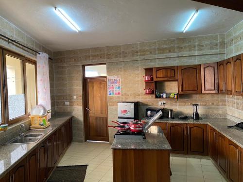 a kitchen with wooden cabinets and a counter top at Haydenco Suites Mombasa-Nyali Furnished Apartments in Mombasa