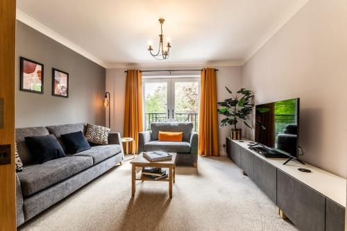 a living room with a couch and a tv at Stylish townhouse by the Quay with parking in Exeter