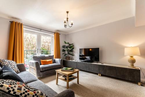 a living room with a couch and a tv at Stylish townhouse by the Quay with parking in Exeter