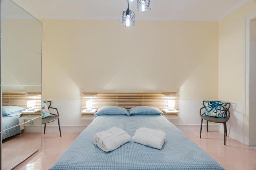 a bedroom with a blue bed with two pillows at Casetta Fardella 95 in Trapani