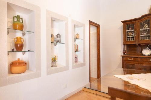 切列梅萨皮卡Villa Acqua Azzurra的餐厅里有一张玻璃桌子和架子上的花瓶