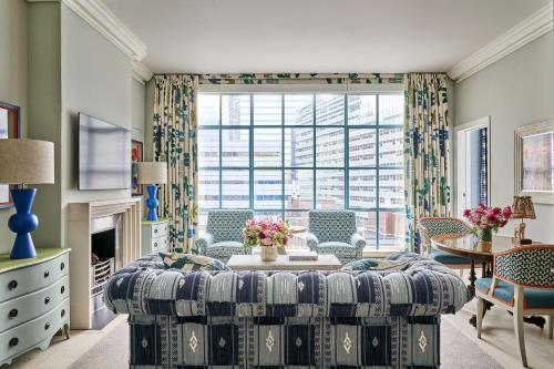 a living room with a couch and a large window at Warren Street Hotel in New York