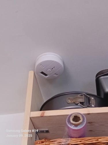 a light on a wall next to a shelf with a toilet at 42 Churchbury Rd, Room 3 in Eltham