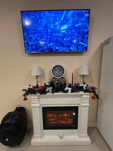 a living room with a fireplace with a tv above it at Eden Villa in Ocina de Jos