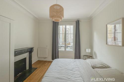 une chambre blanche avec un lit et une cheminée dans l'établissement Flexliving - whole house - Gabriel Peri, à Levallois-Perret