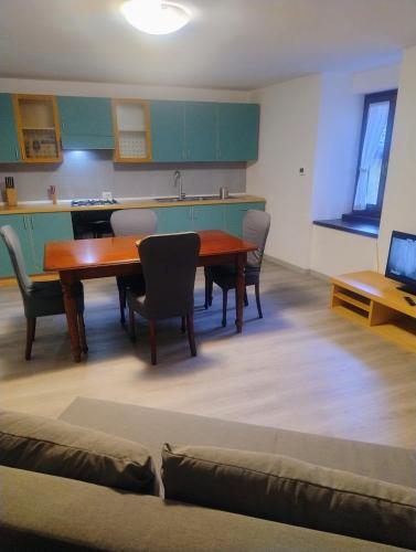 a dining room with a table and chairs and a kitchen at Cà d'Elsa in Pieve Vergonte