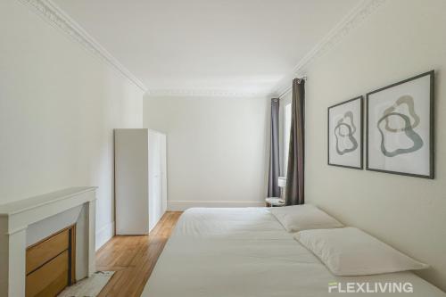 une chambre blanche avec un lit et une cheminée dans l'établissement Flexliving - whole house - Hoche, à Levallois-Perret