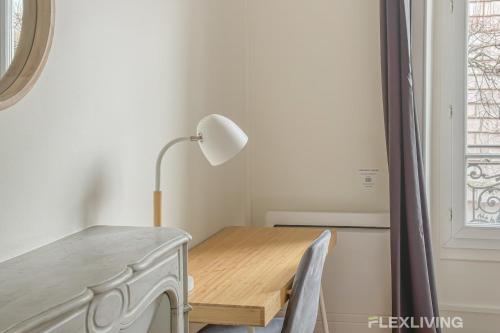 une table à manger avec une lampe et un bureau dans l'établissement Flexliving - whole house - Gabriel Peri, à Levallois-Perret