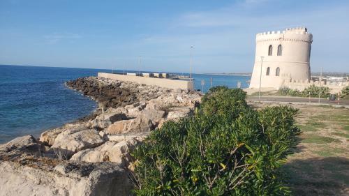 a lighthouse on top of a cliff near the ocean at Casa Cassiano in Patù