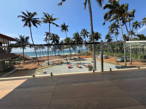 une vue sur une plage avec des palmiers et l'océan dans l'établissement Vista Oceano Beach Resort, à Varkala