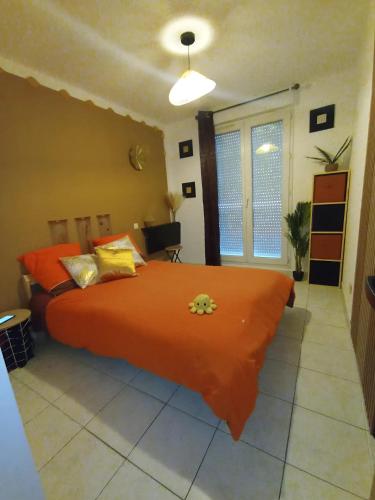 - une chambre avec un grand lit orange et des oreillers jaunes dans l'établissement Grand T2 avec terrasse, à Marseille