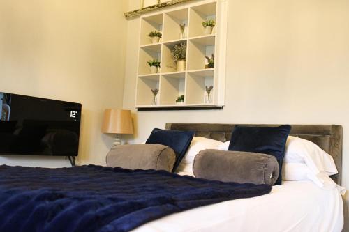 a bedroom with a bed with a blue blanket at Beautiful Cotswold Couples Retreat in Bourton on the Water