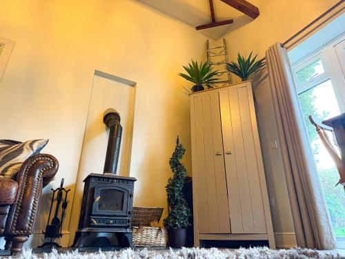 a room with a wood stove in the corner at Beautiful Cotswold Couples Retreat in Bourton on the Water