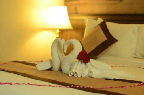 two swans made out of towels on a bed at Varna Culture Hotel Soerabaia in Surabaya