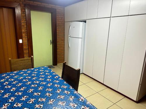 a kitchen with a table and a refrigerator at Quarto privativo completo no Centro in Botucatu