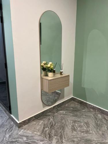 a mirror on a wall with a table and flowers at Chambres d'Hôtes Centre Ville in Dakar