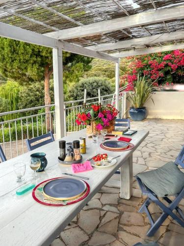 - une table de pique-nique avec des assiettes de nourriture sur la terrasse dans l'établissement Maison Vue Mer à Lumio avec Terrasse et Jardin Clos, à Lumio