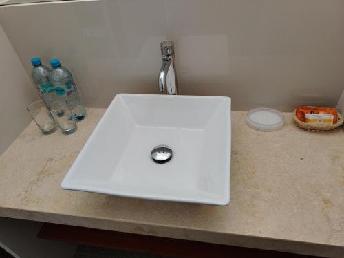 a white sink on a counter with two bottles of water at Casa Yuraq Hotel Boutique in Chincha Alta