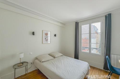 une chambre blanche avec un lit et une fenêtre dans l'établissement Flexliving - whole house - Gabriel Peri, à Levallois-Perret