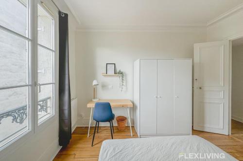 - une chambre avec un bureau et une chaise bleue dans l'établissement Flexliving - whole house - Gabriel Peri, à Levallois-Perret