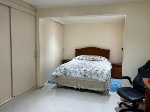 ein Schlafzimmer mit einem Bett und einem Stuhl darin in der Unterkunft Casa Condominio la Bahía in Coquimbo