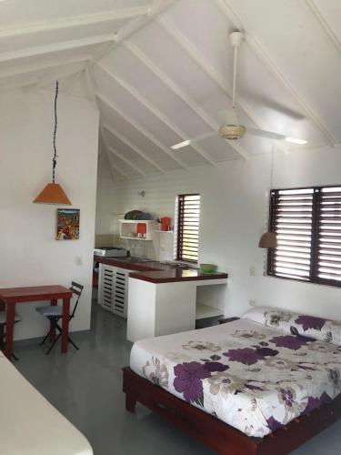 Una habitación blanca con una cama y una cocina. en Hotel Casa Robinson, en Las Terrenas