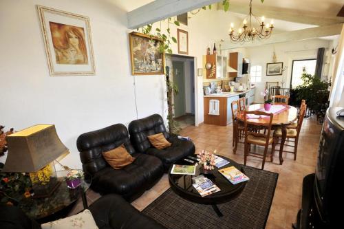 un salon avec un canapé en cuir et une table dans l'établissement La bergerie de vaulongue a 3km de la mer mediterranee, à Saint-Raphaël