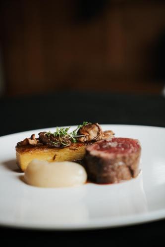 a plate of food with a piece of bread and meat at Tirolensis - Luxury All Inclusive in Tesimo