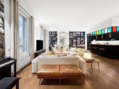 a living room with a white couch and a piano at Vue Canal, 3 Suites & Double Salon in Sète