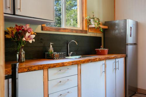 a kitchen with a sink and a refrigerator at Cabaña Ciervo in Puerto Varas