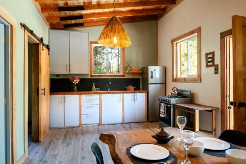 a kitchen with a wooden table and a dining room at Cabaña Ciervo in Puerto Varas