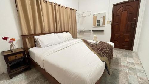 a bedroom with a bed and a wooden door at บ้านเพื่อน @อุทัยธานี in Ban Don Khwang