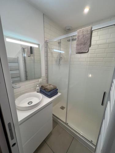une salle de bain blanche avec une douche et un lavabo dans l'établissement Grand Chelem 2, à Le Touquet-Paris-Plage