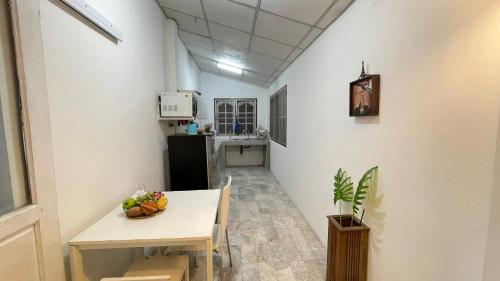 a kitchen with a table with a bowl of fruit on it at บ้านเพื่อน @อุทัยธานี in Ban Don Khwang
