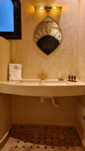 a bathroom with a sink and a mirror at Villa AMMA in Essaouira