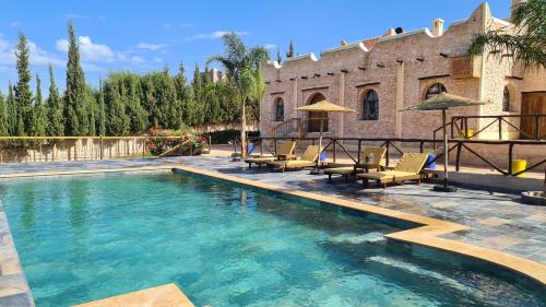 a swimming pool with chairs and a house at Villa AMMA in Essaouira