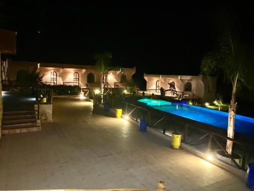 an outdoor swimming pool at night with lights at Villa AMMA in Essaouira
