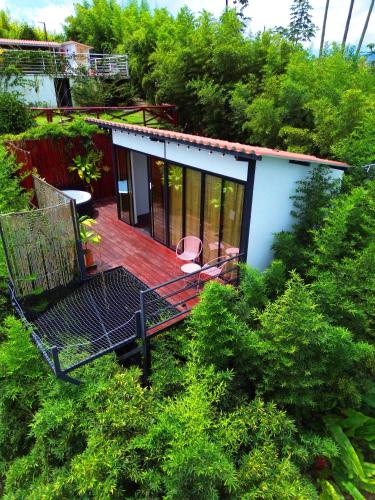 a house with a deck with a chair on it at La Paloma Glamping in Palestina