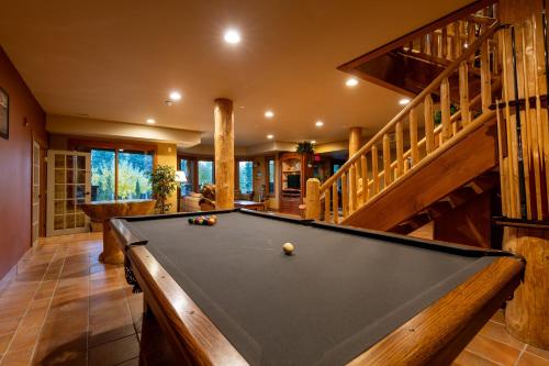 a pool table in a room with a staircase at Vagabond Lodge at Kicking Horse in Golden