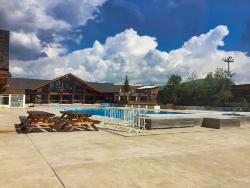 une piscine avec des tables de pique-nique et un bâtiment dans l'établissement Studio avec coin montagne et belle vue panoramique, à Huez