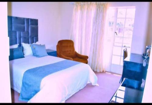 una camera da letto con un letto, una sedia e una finestra di Baobab Garden a Harare