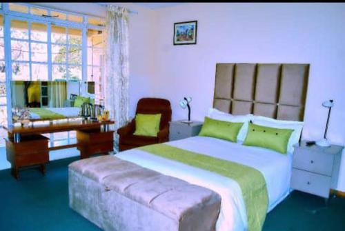 una grande camera da letto con un letto grande e una sedia di Baobab Garden a Harare
