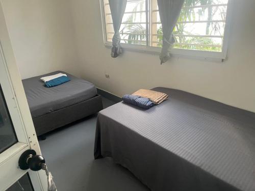 two beds sitting in a room with a window at Habitación cerca de la playa 204 in Cartagena de Indias