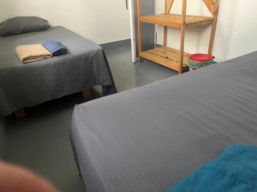 a room with two beds and a wooden shelf at Habitación cerca de la playa 204 in Cartagena de Indias