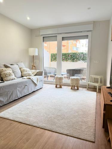 a living room with a bed and a large window at Reformado Centro con Terraza in Castro-Urdiales