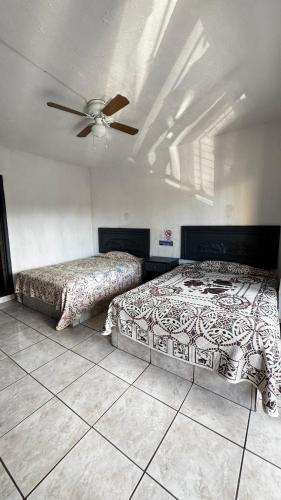 a bedroom with two beds and a ceiling fan at Hotel Nuevo Vallarta in Guadalajara